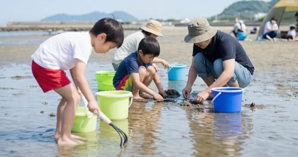 家族で潮干狩りに熱中している画像